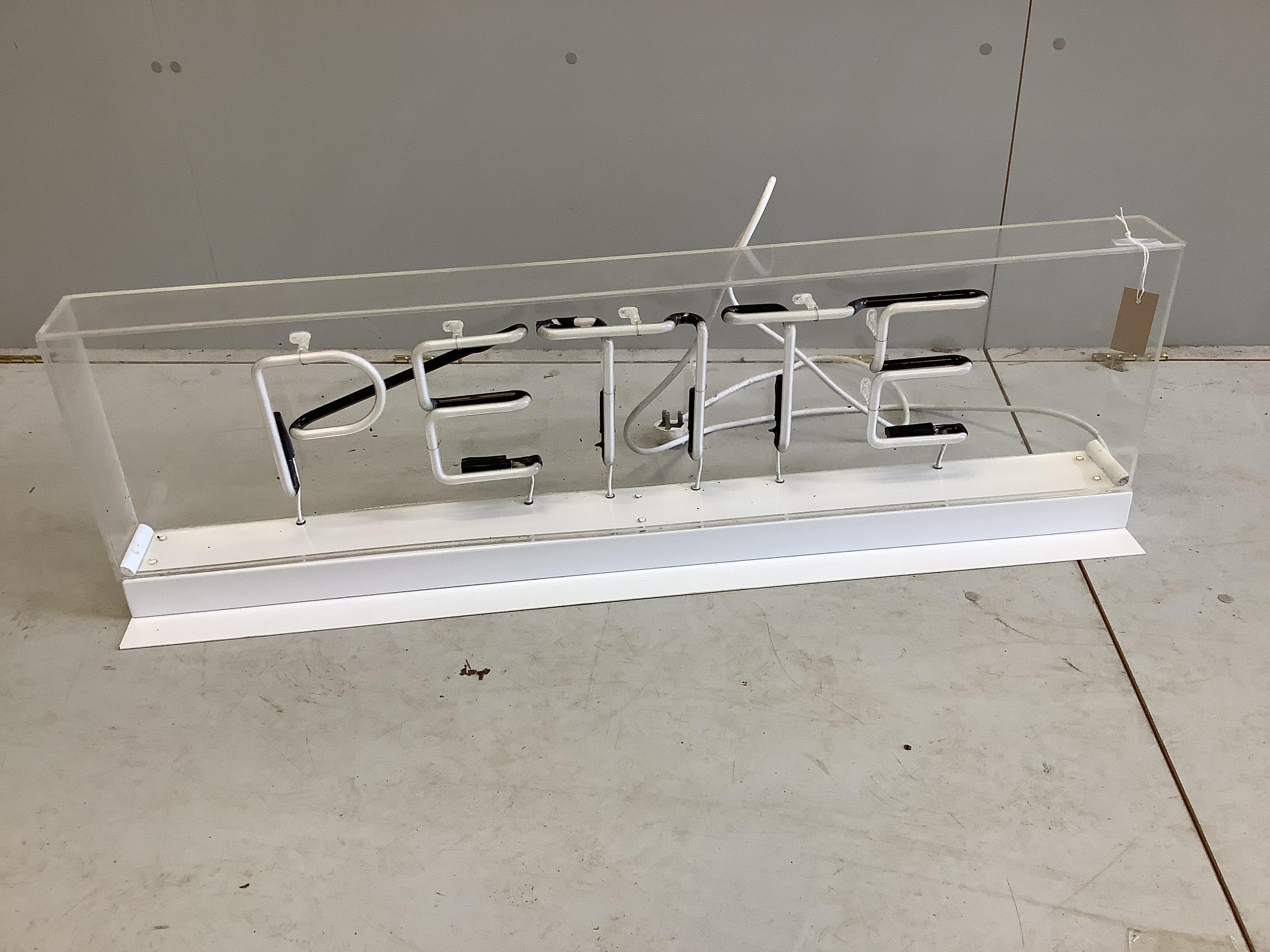 A neon 'Petite' illuminated shop sign, width 115cm, height 35cm (This is in full working order and PAT tested)